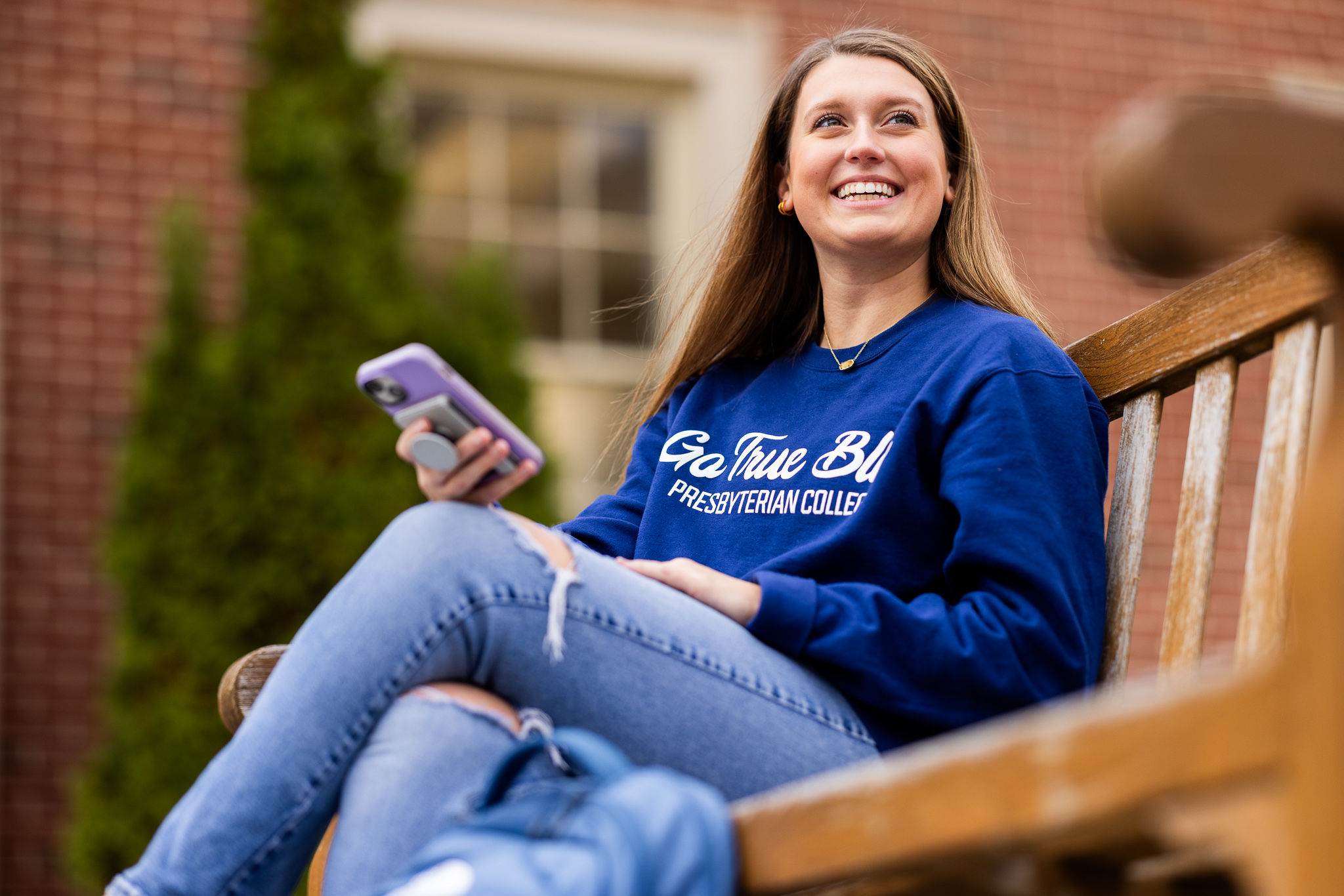 Student sitting on bench and looking at phone